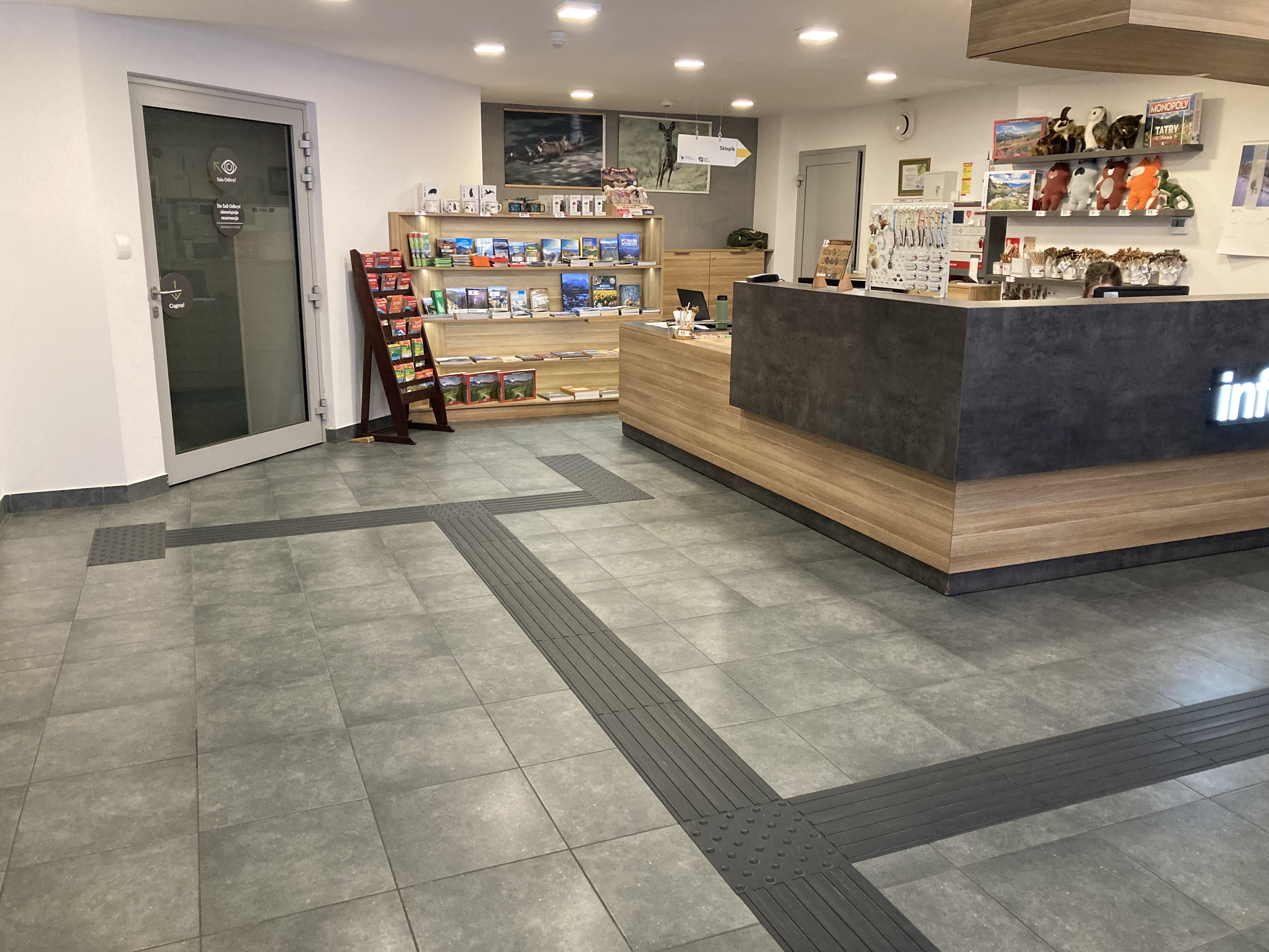 Linie naprowadzające do obniżonej lady w Punkcie Informacji Turystycznej Centrum Edukacji Przyrodniczej Tatrzańskiego Parku Narodowego i sklepiku z pamiątkami. 