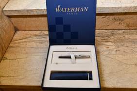 Pokaż zdjęcie: Na stole leży pióro w pamiątkowym opakowaniu