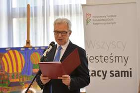Pokaż zdjęcie: Mężczyzna mówi do mikrofonu 