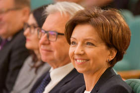 Pokaż zdjęcie: Uśmiechnięta twarz kobiety widoczna z profilu 