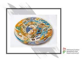 Pokaż zdjęcie: pocztówka z płaskorzeźbą z ubiegłorocznego konkursu - talerz z napisem Polska i  symbolami m.in. pałacem kultury i nauki, fortepianem, nutami, morzem, latarnią morską, kamieniczkami.