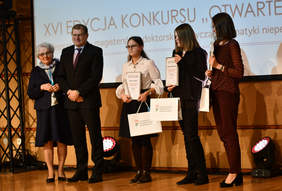 Pokaż zdjęcie: Osoby stoją na scenie i pozują do zdjęcia